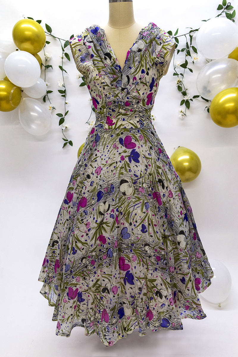 Photograph of a 1950s sleeveless silk floral print dress with a full skirt.